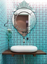 Esse lavabo pequenininho tem um monte de ideias: uma bancada natural de madeira, uma pia de design moderno, e um espelho veneziano. Pra completar e dar todo aquele charme, um papel cheio de personalidade, no azul turquesa, uma cor muito forte atualmente.