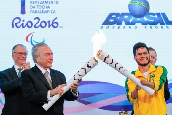 O presidente interino Michel Temer e o velocista Yohansson Nascimento acendem a tocha paralímpica no Palácio do Planalto