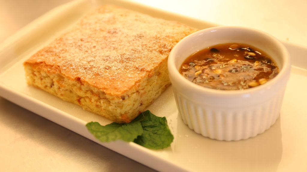 Brownie com Chocolate Branco com Castanha de Caju e calda de Maracujá